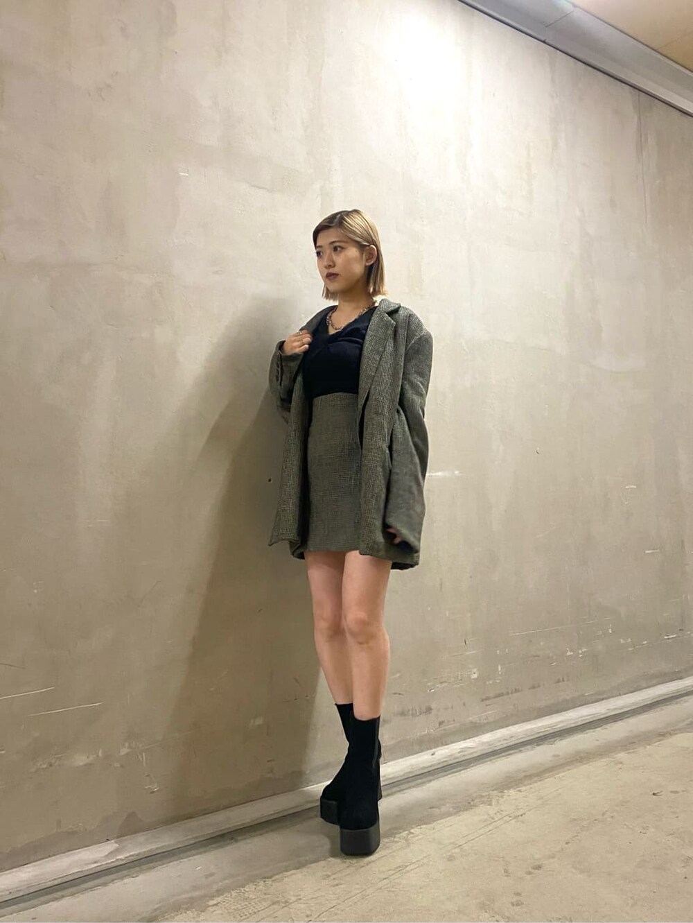 ベージュ系のテーラードジャケット、ベージュ系のスカート、ブラック系のブーツを着用したレディースの秋コーディネートの6枚目の写真