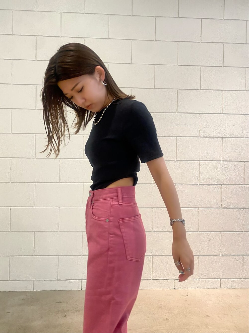 ピンク系のデニムパンツ、ブラック系のTシャツ/カットソー、シルバー系のネックレスを着用したレディースの夏コーディネートの8枚目の写真