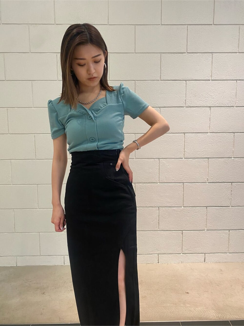 ブラック系のサンダル、ブラック系のスカート、ブルー系のTシャツ/カットソーを着用したレディースの夏コーディネートの7枚目の写真