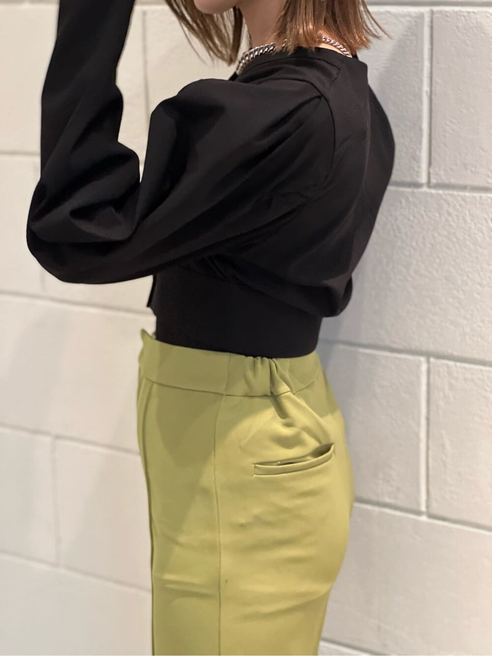 イエロー系のその他パンツ、ブラック系のTシャツ/カットソー、ブラック系のブーツを着用したレディースの春コーディネートの6枚目の写真