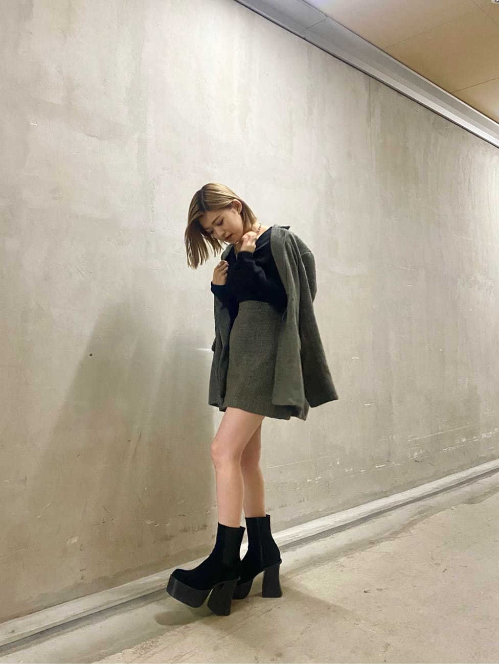 ベージュ系のテーラードジャケット、ベージュ系のスカート、ブラック系のブーツを着用したレディースの秋コーディネートの5枚目の写真