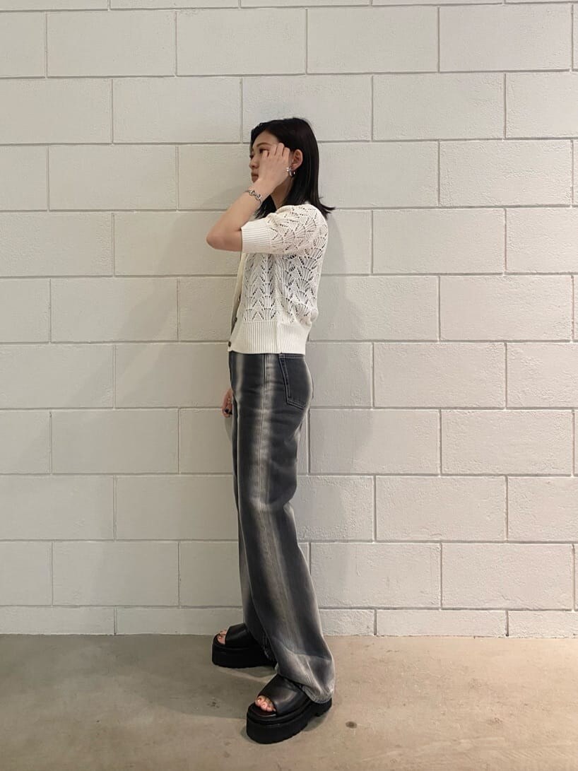 ブラック系のサンダル、ブラック系のデニムパンツ、ホワイト系のニット/セーターを着用したレディースの春コーディネートの2枚目の写真