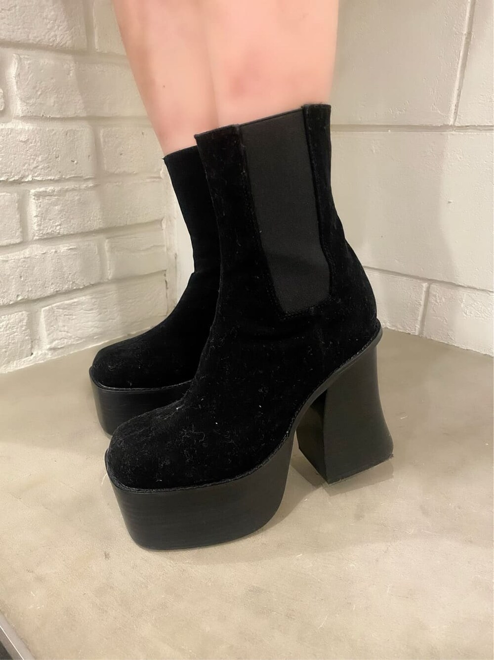 ブラック系のスカート、ブラック系のショルダーバッグ、ブラック系のブーツを着用したレディースの冬コーディネートの6枚目の写真