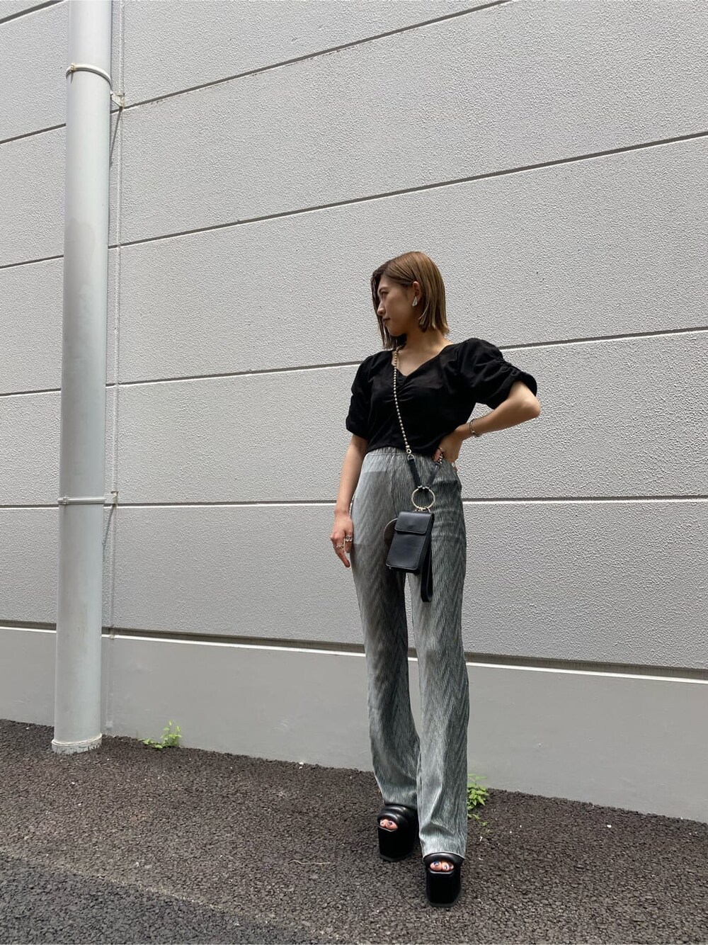 グリーン系のその他パンツ、ブラック系のサンダル、ブラック系のハンドバッグを着用したレディースの夏コーディネートの2枚目の写真