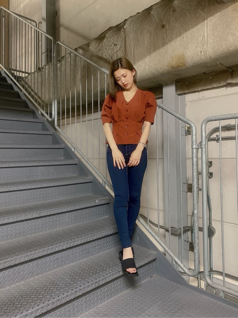 ブラック系のサンダル、ブルー系のデニムパンツを着用したレディースの夏コーディネートの3枚目の写真