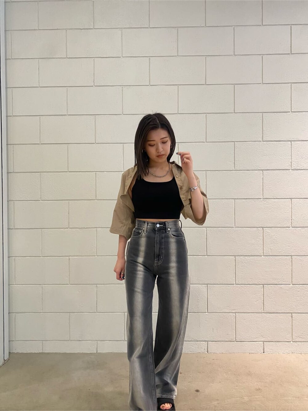 ベージュ系のシャツ/ブラウス、ブラック系のデニムパンツ、ブラック系のサンダルを着用したレディースの春コーディネートの5枚目の写真