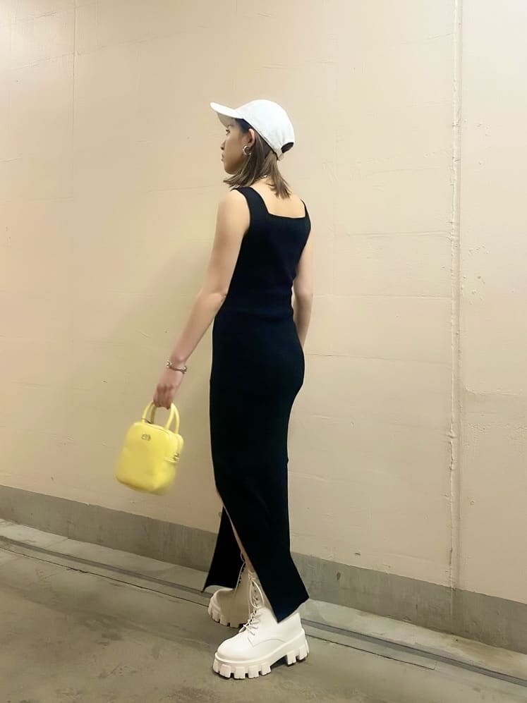 ホワイト系のブーツ、イエロー系のショルダーバッグ、ブラック系のワンピースを着用したレディースの春コーディネートの4枚目の写真