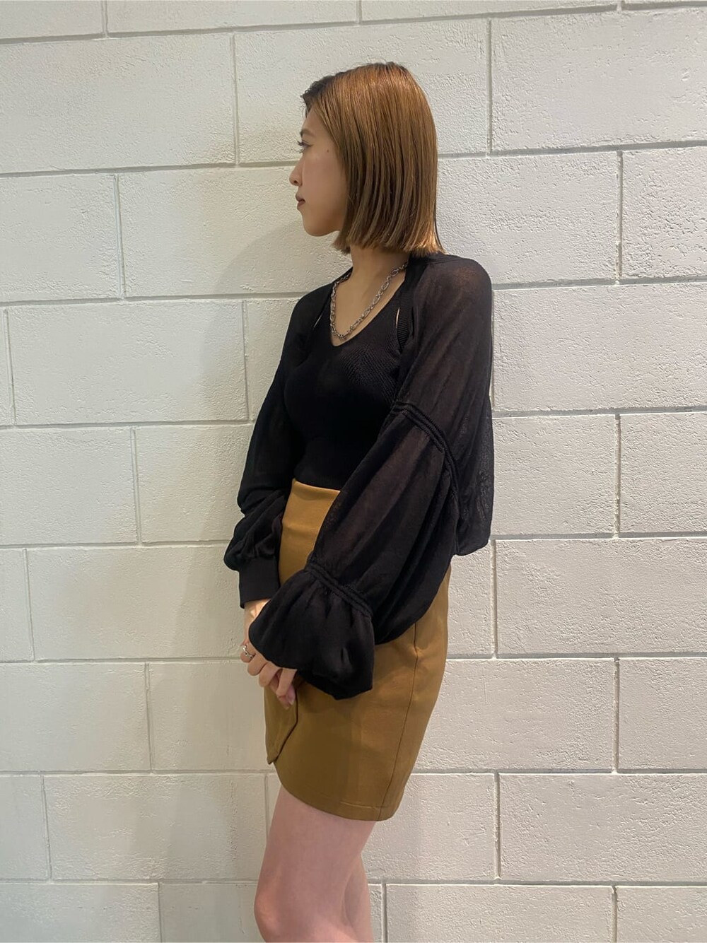 イエロー系のスカート、ブラック系のサンダル、ブラック系のカーディガン/ボレロを着用したレディースの夏コーディネートの3枚目の写真