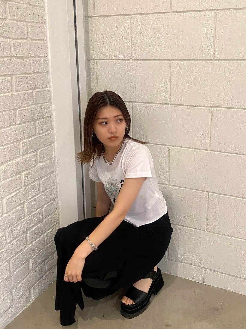 ブラック系のスカート、ブラック系のサンダル、ホワイト系のTシャツ/カットソーを着用したレディースの夏コーディネートの6枚目の写真