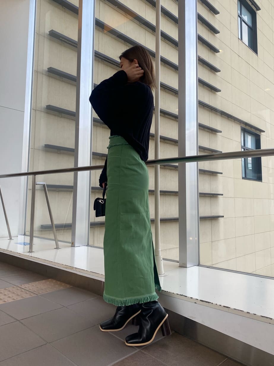 ブラック系のニット/セーター、ブラック系のブーツ、ブラック系のハンドバッグを着用したレディースの冬コーディネートの2枚目の写真