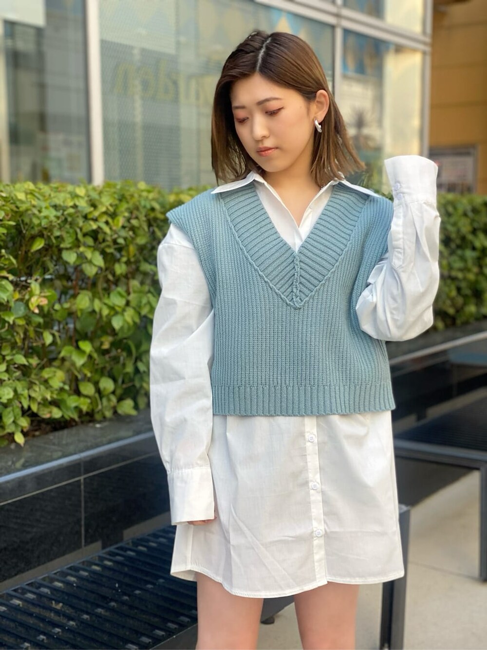 ホワイト系のシャツ/ブラウス、ブラック系のブーツ、ブルー系のベストを着用したレディースの春コーディネートの4枚目の写真