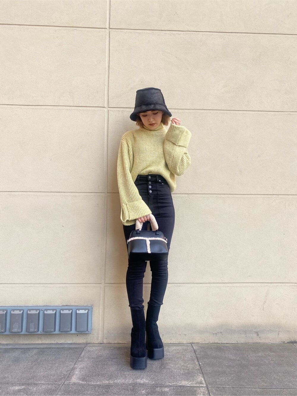 ブラック系のブーツ、ブラック系のハンドバッグ、イエロー系のニット/セーターを着用したレディースの秋コーディネートの8枚目の写真