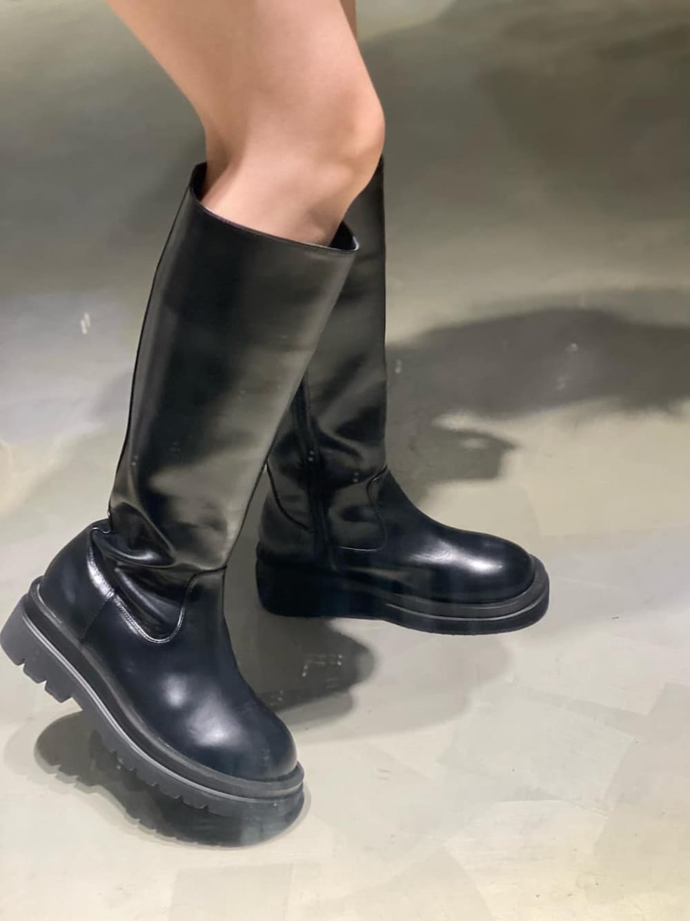 パープル系のワンピース、ブラック系のブーツを着用したレディースの秋コーディネートの5枚目の写真