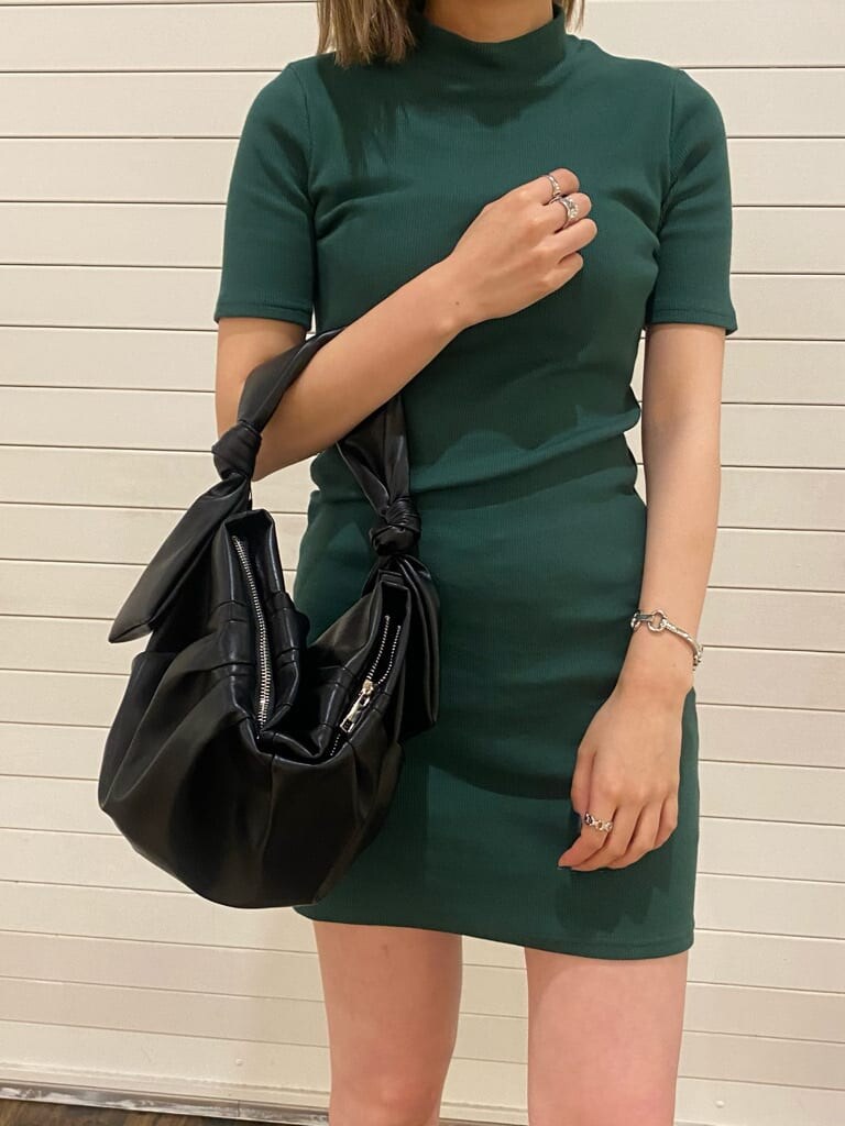 ブラック系のハンドバッグ、グリーン系のワンピース、ブラック系のサンダルを着用したレディースの夏コーディネートの2枚目の写真