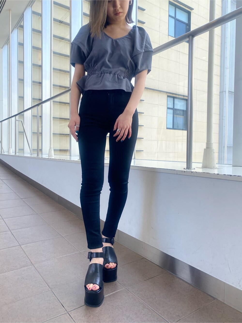 グレー系のシャツ/ブラウス、ブラック系のデニムパンツ、ブラック系のサンダルを着用したレディースの春コーディネートの6枚目の写真