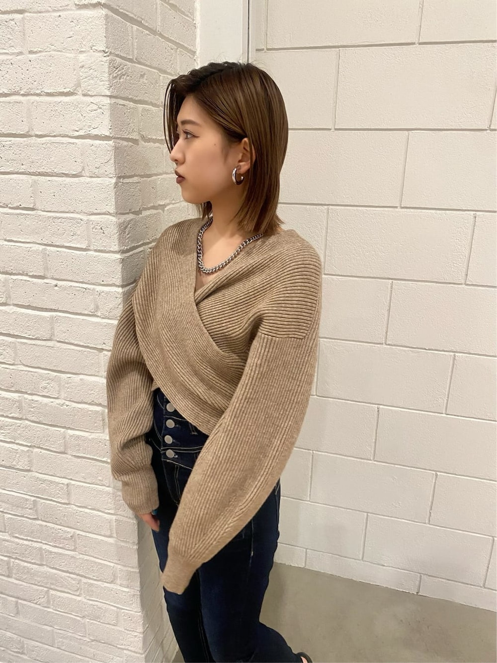 ブルー系のデニムパンツ、ブラック系のローファー、ベージュ系のニット/セーターを着用したレディースの冬コーディネートの6枚目の写真