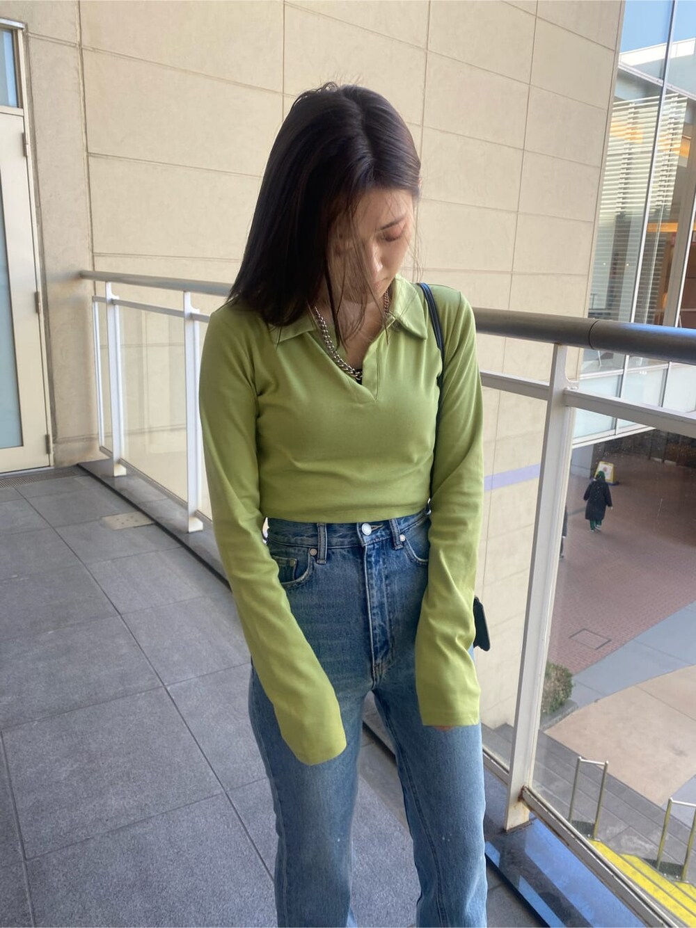 ブラック系のブーツ、ブルー系のデニムパンツ、イエロー系のTシャツ/カットソーを着用したレディースの冬コーディネートの4枚目の写真