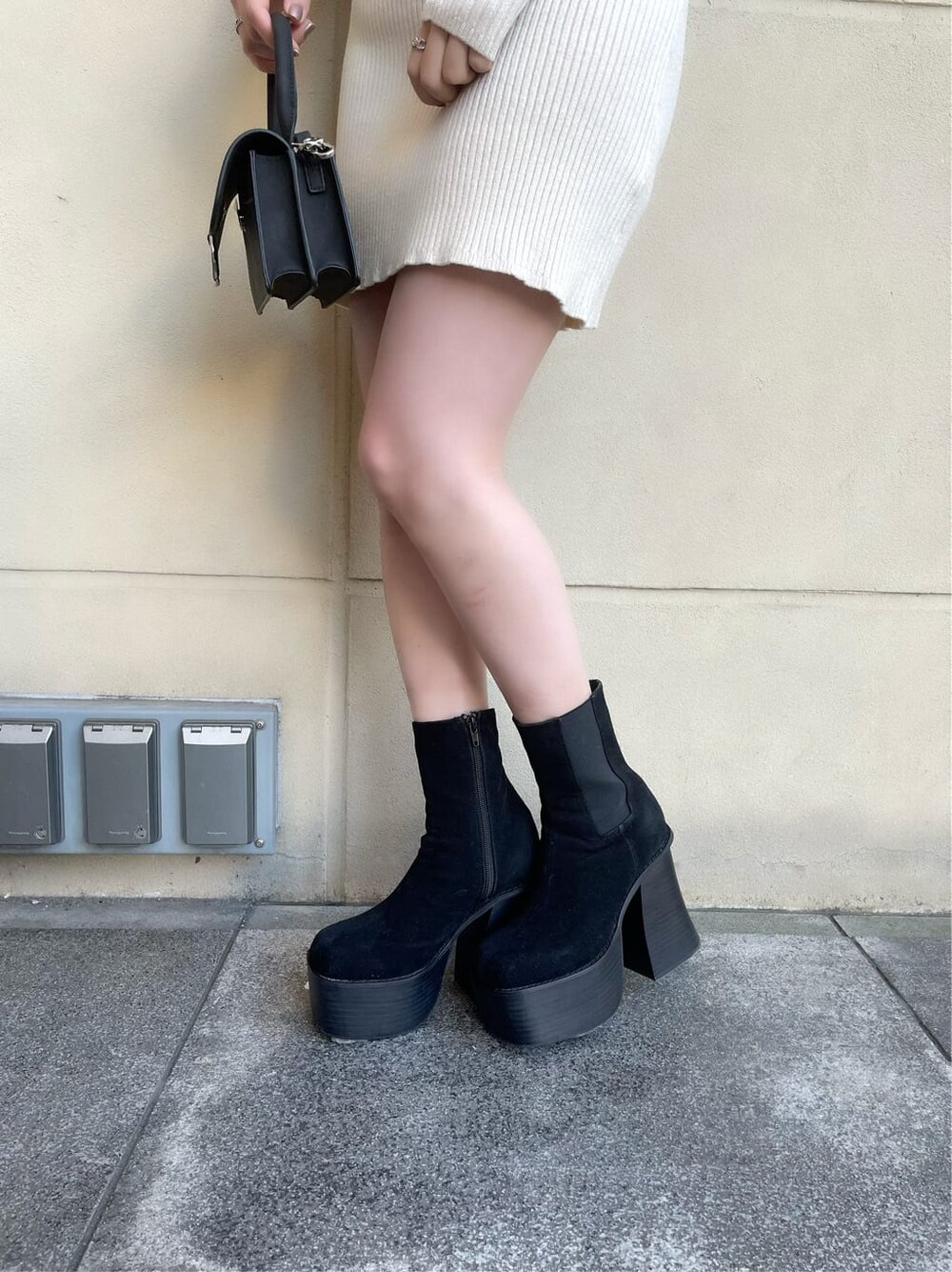 ブラック系のブーツ、ベージュ系のその他アウター、ホワイト系のワンピースを着用したレディースの冬コーディネートの7枚目の写真