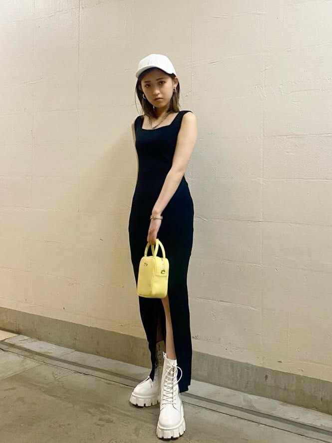 ホワイト系のブーツ、イエロー系のショルダーバッグ、ブラック系のワンピースを着用したレディースの春コーディネートの3枚目の写真