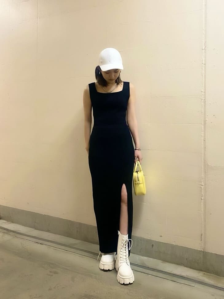 ホワイト系のブーツ、イエロー系のショルダーバッグ、ブラック系のワンピースを着用したレディースの春コーディネートの2枚目の写真