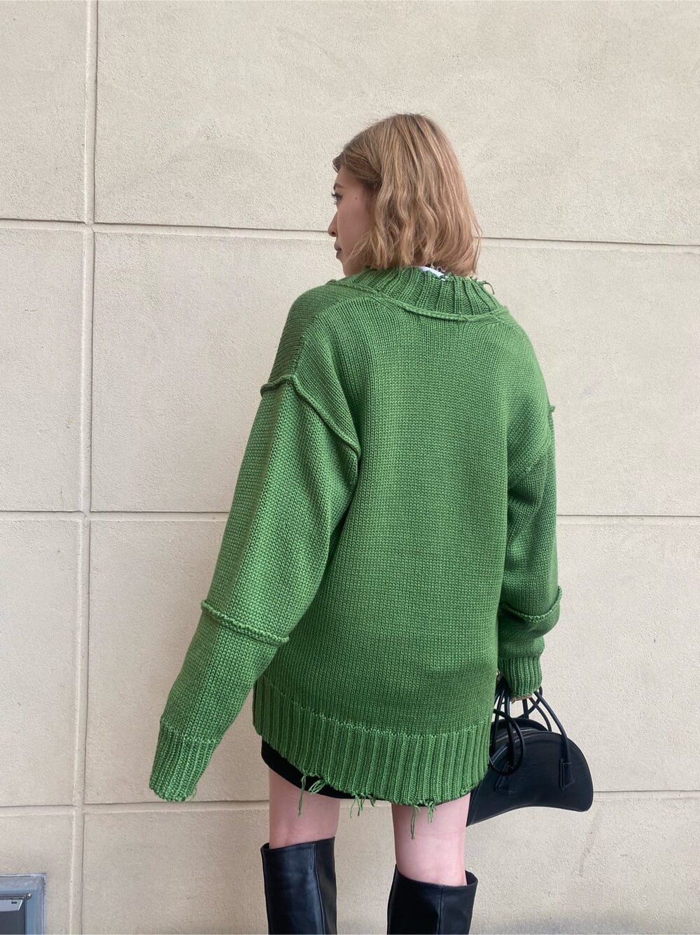 ブラック系のスカート、ブラック系のブーツ、ホワイト系のTシャツ/カットソーを着用したレディースの秋コーディネートの3枚目の写真