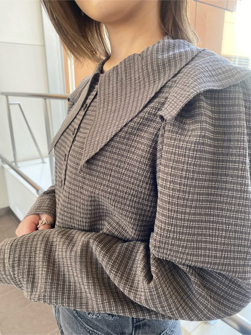 ホワイト系のローファー、グレー系のデニムパンツ、ブラウン系のシャツ/ブラウスを着用したレディースの冬コーディネートの2枚目の写真