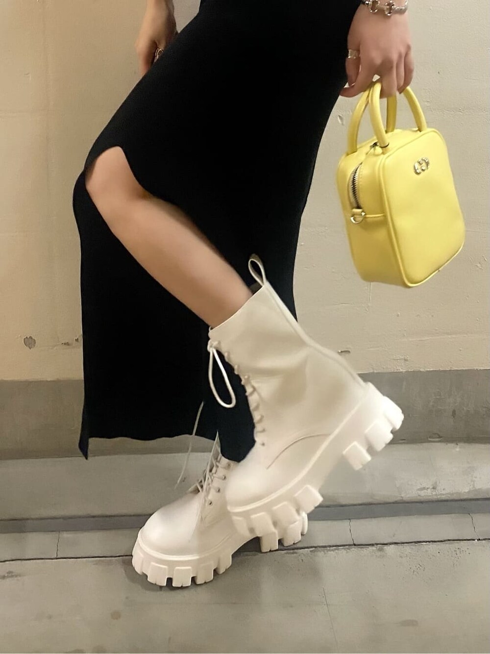 ホワイト系のブーツ、イエロー系のショルダーバッグ、ブラック系のワンピースを着用したレディースの春コーディネートの9枚目の写真