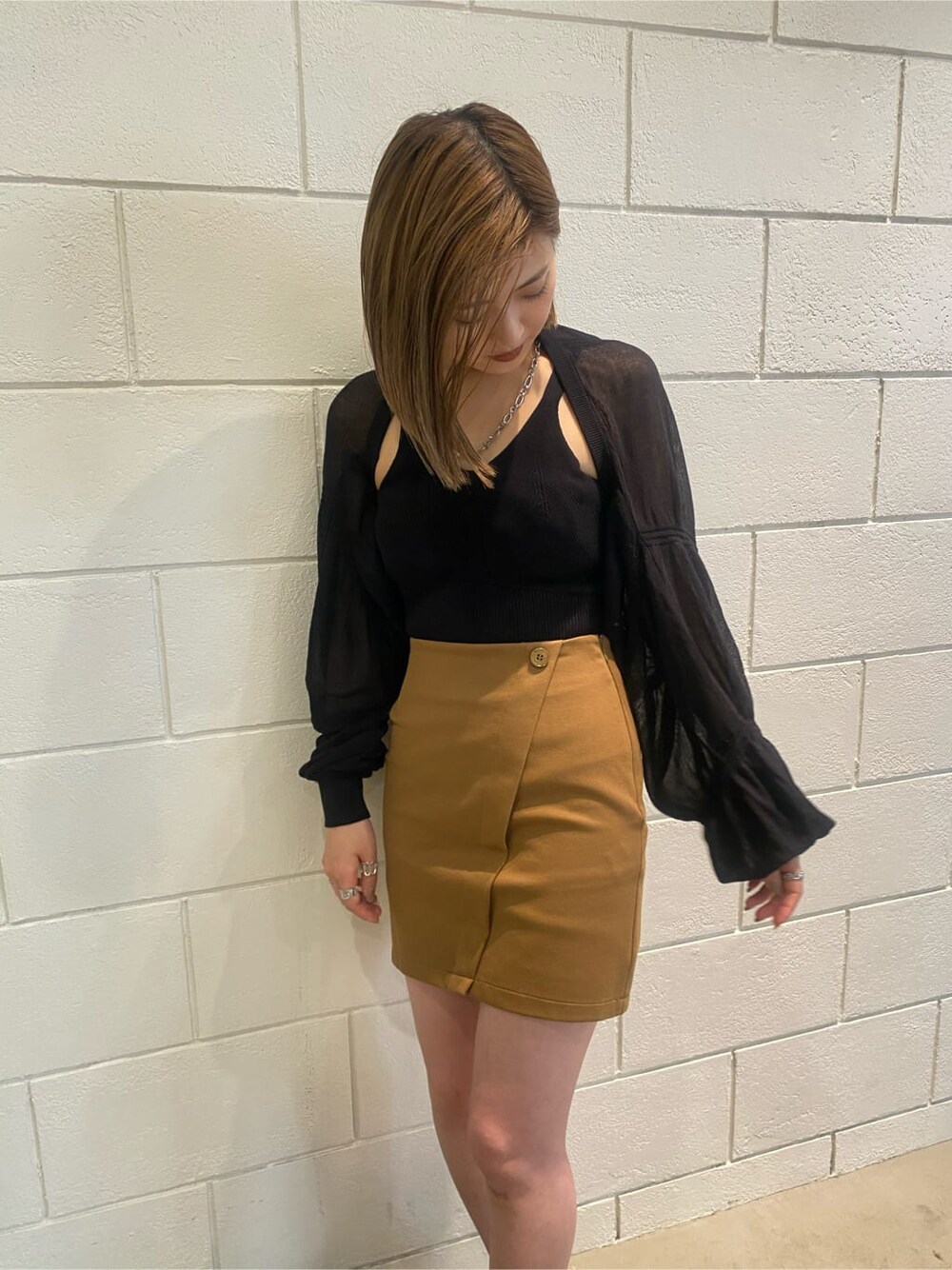 イエロー系のスカート、ブラック系のサンダル、ブラック系のカーディガン/ボレロを着用したレディースの夏コーディネートの4枚目の写真