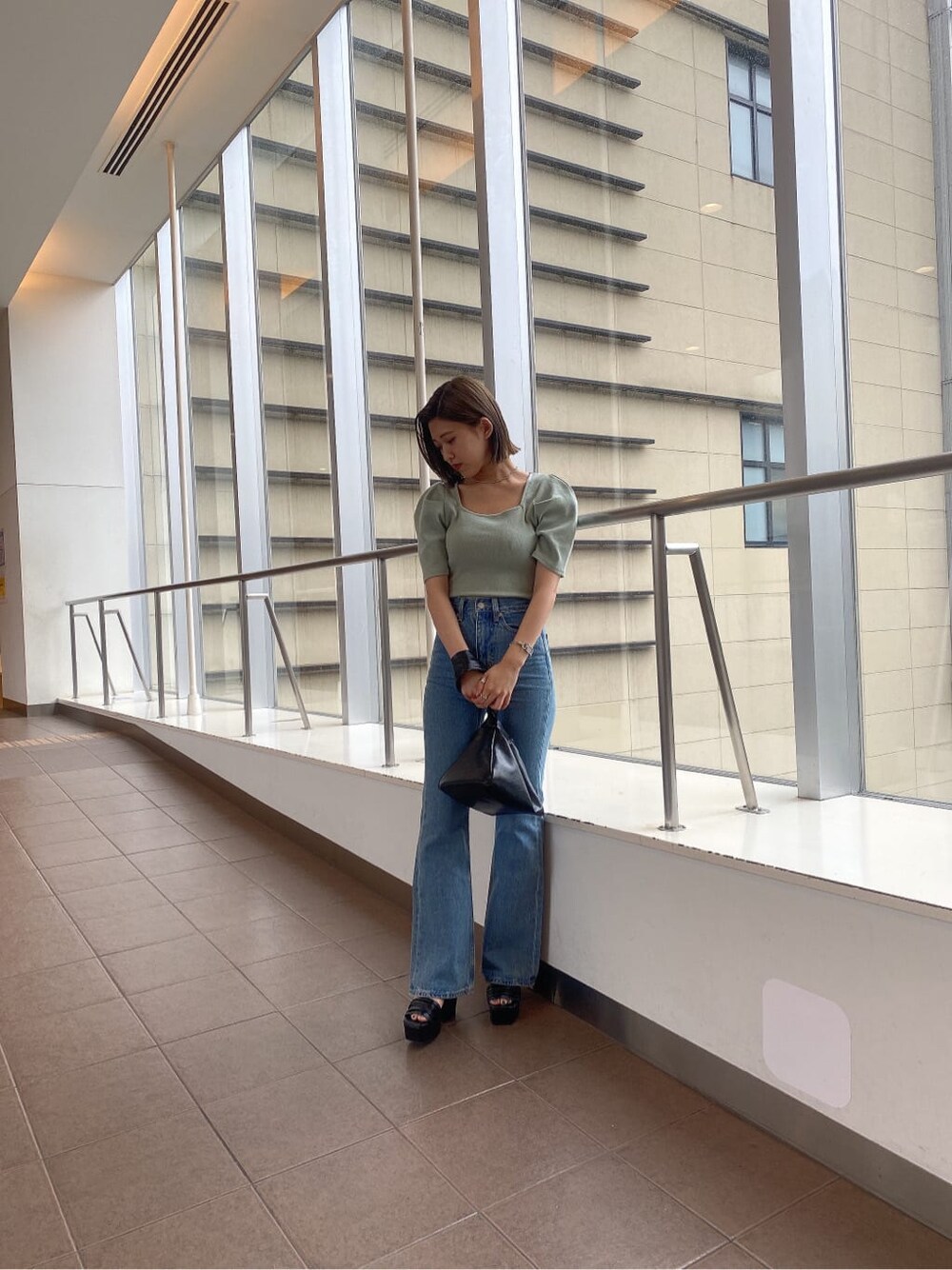 ブラック系のサンダル、グリーン系のTシャツ/カットソー、ブラック系のハンドバッグを着用したレディースの夏コーディネートの7枚目の写真