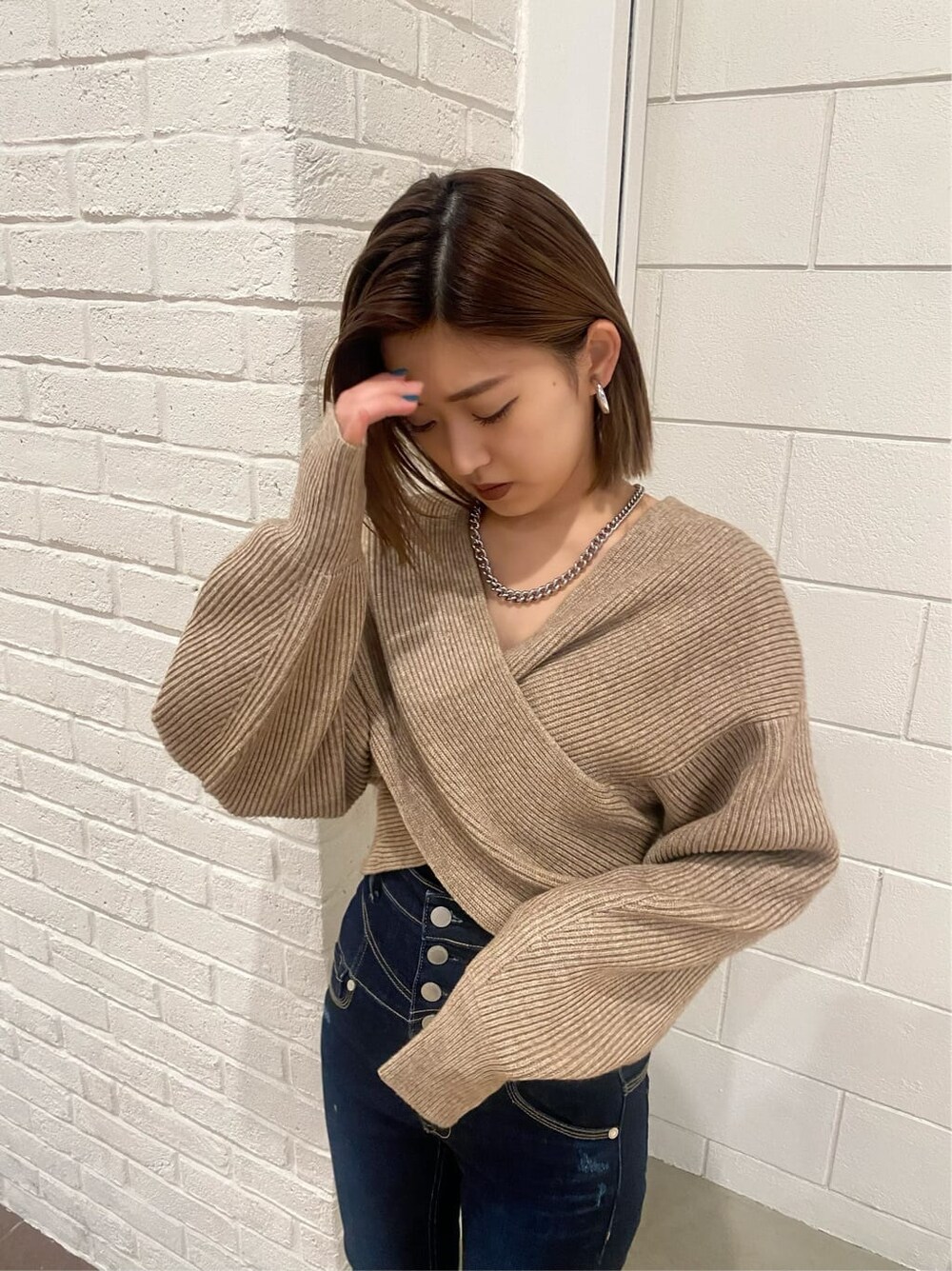 ブルー系のデニムパンツ、ブラック系のローファー、ベージュ系のニット/セーターを着用したレディースの冬コーディネートの7枚目の写真