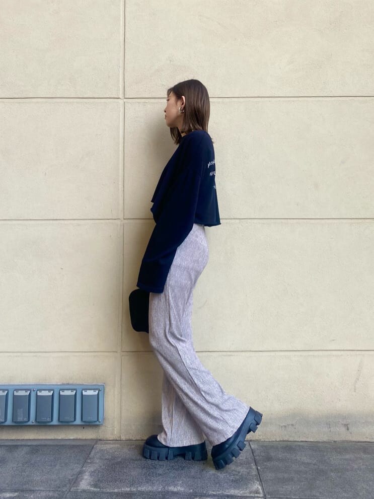 グレー系のその他パンツ、ブラック系のサンダル、ホワイト系のTシャツ/カットソーを着用したレディースの春コーディネートの2枚目の写真