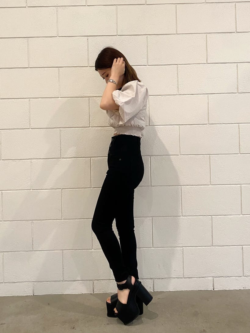 ブラック系のデニムパンツ、ブラック系のサンダル、ホワイト系のTシャツ/カットソーを着用したレディースの夏コーディネートの3枚目の写真