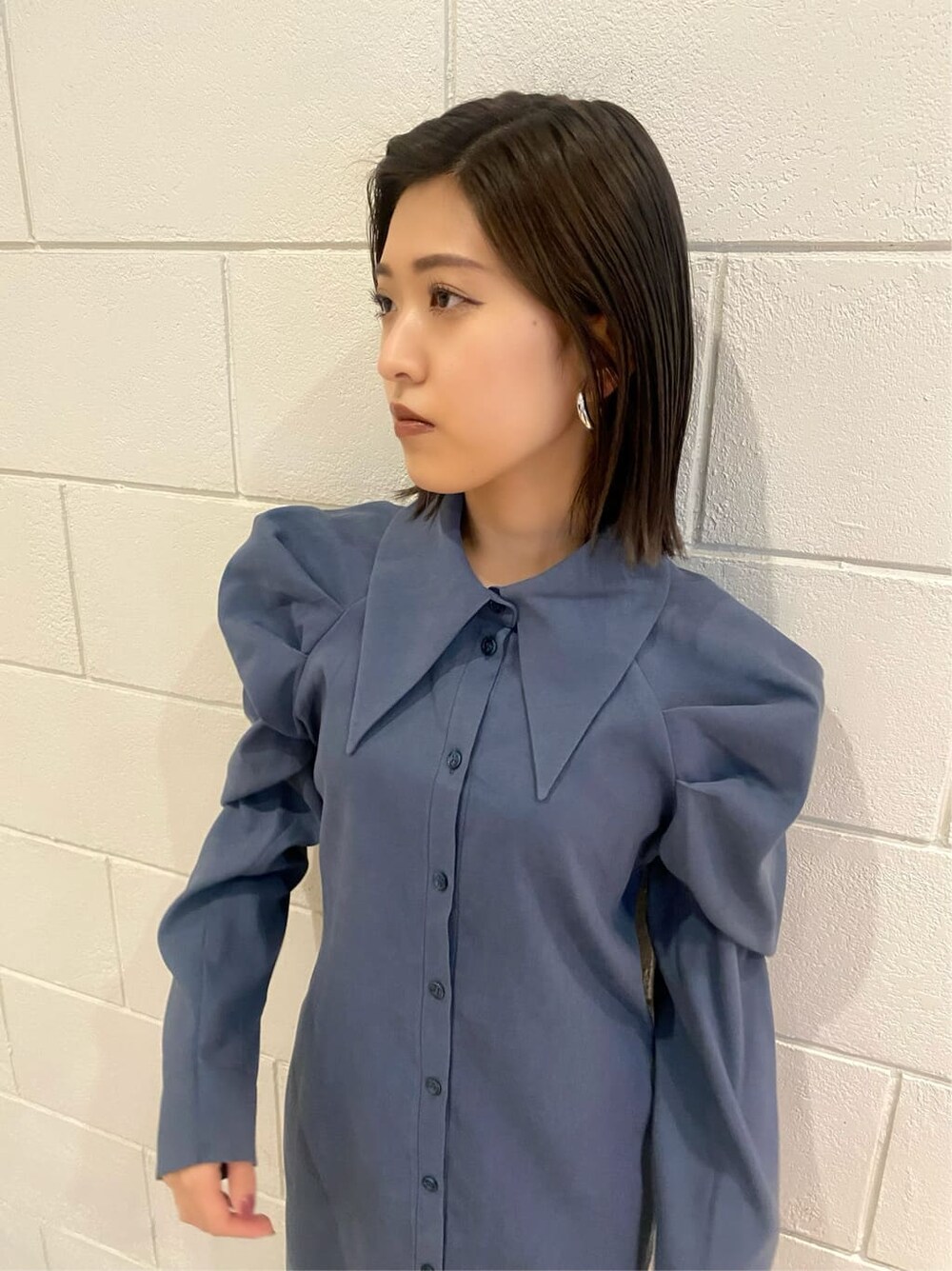 ブルー系のワンピース、ブラック系のブーツを着用したレディースの冬コーディネートの5枚目の写真