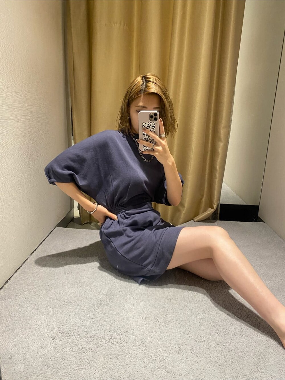 パープル系のワンピース、ブラック系のブーツを着用したレディースの秋コーディネートの2枚目の写真