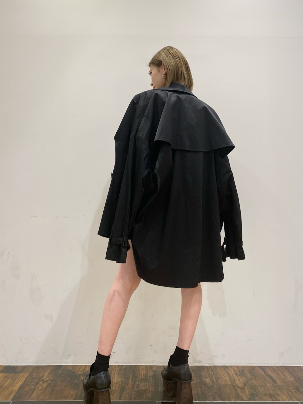 ブラック系のスカート、ブラック系のトレンチコート、グレー系のスウェットを着用したレディースの春コーディネートの2枚目の写真