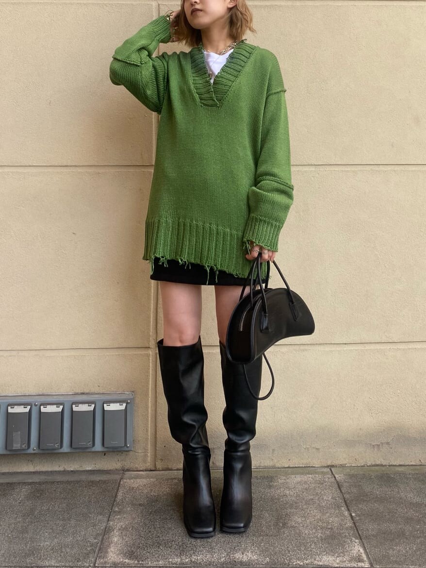 ブラック系のスカート、ブラック系のブーツ、ホワイト系のTシャツ/カットソーを着用したレディースの秋コーディネートの2枚目の写真