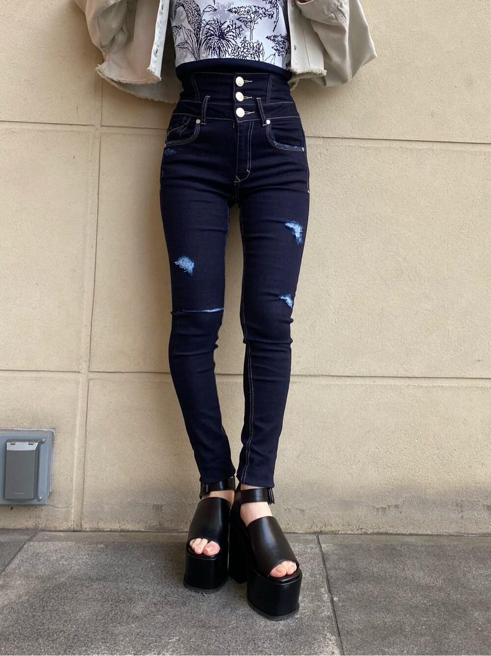 ブルー系のデニムパンツ、ホワイト系のデニムジャケット、ブラック系のサンダルを着用したレディースの春コーディネートの5枚目の写真