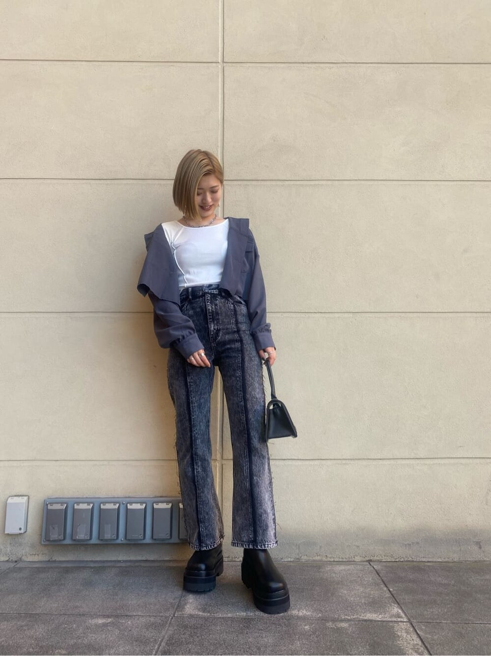 ブルー系のテーラードジャケット、ブラック系のハンドバッグ、ホワイト系のTシャツ/カットソーを着用したレディースの夏コーディネートの2枚目の写真