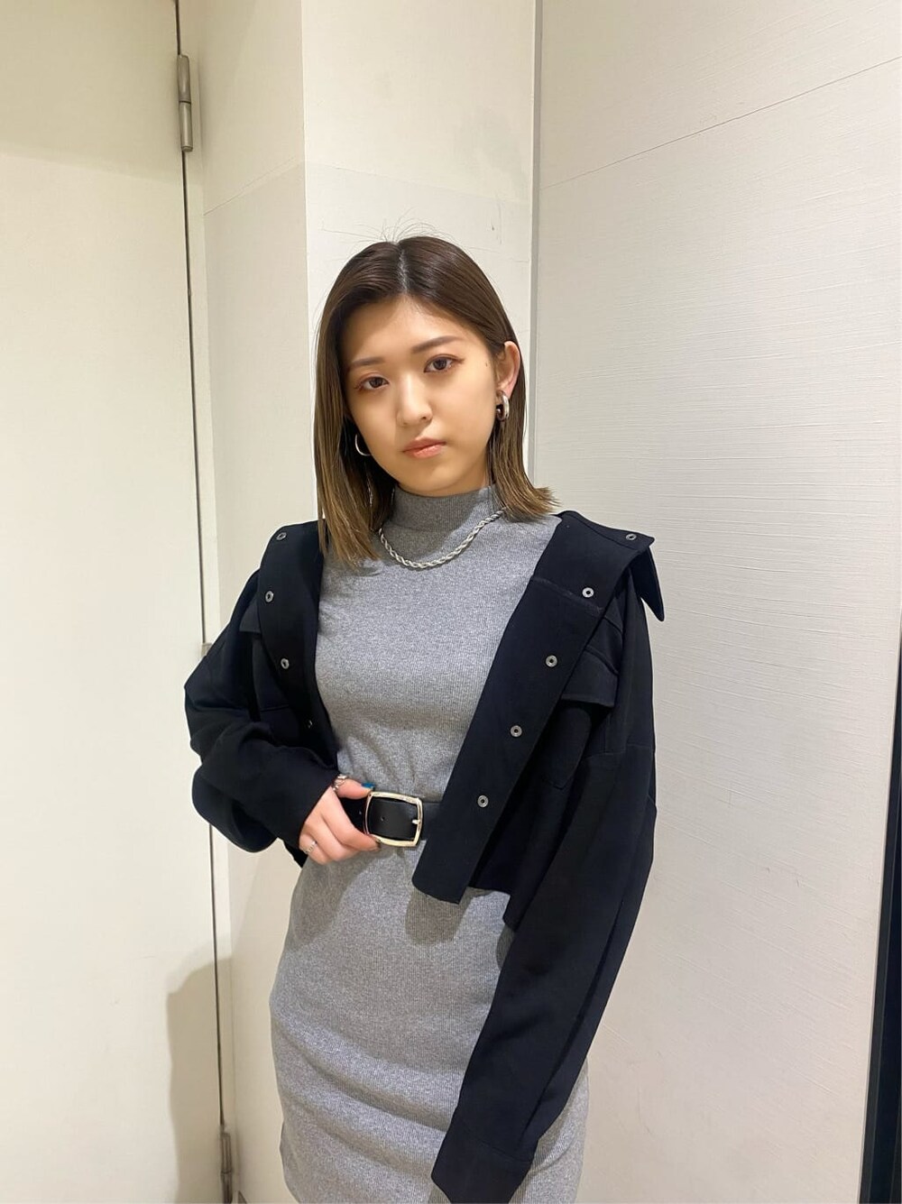 ブラック系のブルゾン、グレー系のワンピース、ブラック系のサンダルを着用したレディースの春コーディネートの4枚目の写真