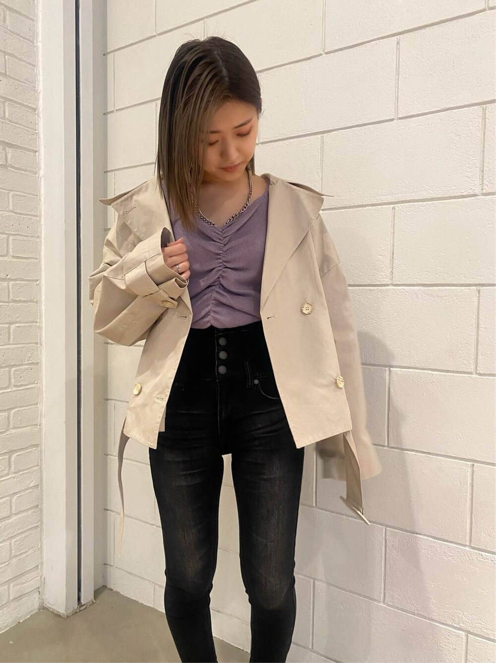 ベージュ系のトレンチコート、ブラック系のローファー、パープル系のニット/セーターを着用したレディースの冬コーディネートの4枚目の写真