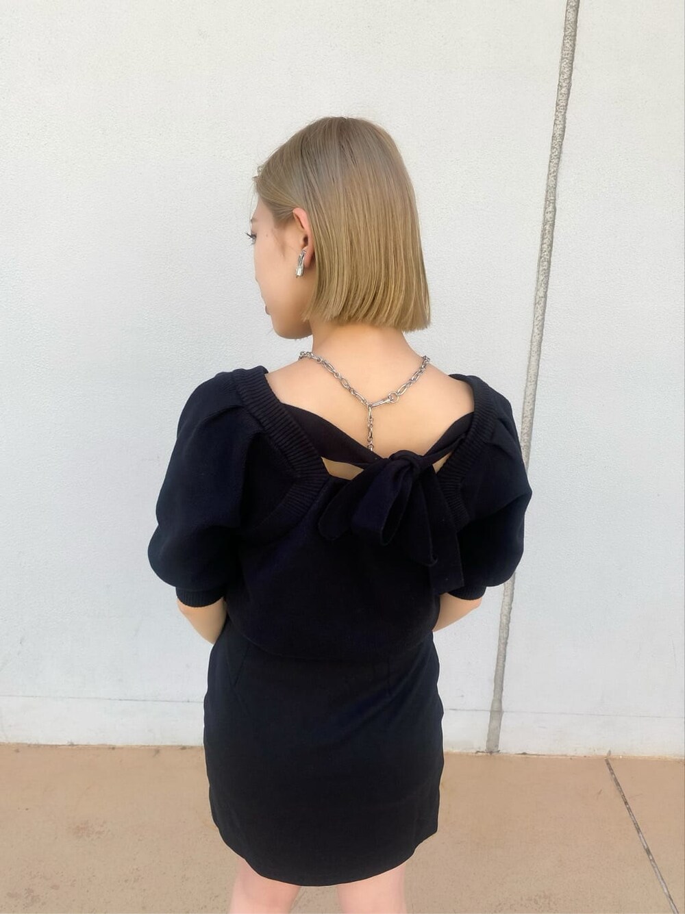 ベージュ系のトレンチコート、ブラック系のスカート、グリーン系のハンドバッグを着用したレディースの夏コーディネートの9枚目の写真