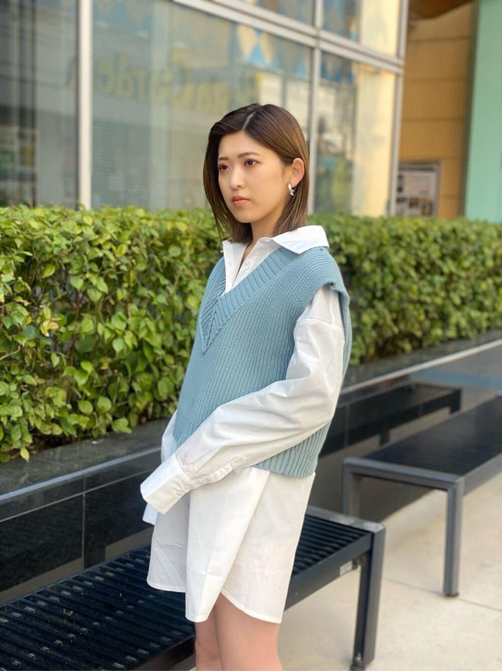 ホワイト系のシャツ/ブラウス、ブラック系のブーツ、ブルー系のベストを着用したレディースの春コーディネートの5枚目の写真