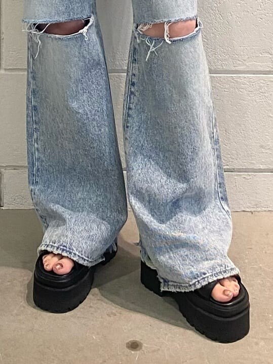 ブラック系のサンダル、ホワイト系のハンドバッグ、ブルー系のデニムパンツを着用したレディースの夏コーディネートの10枚目の写真