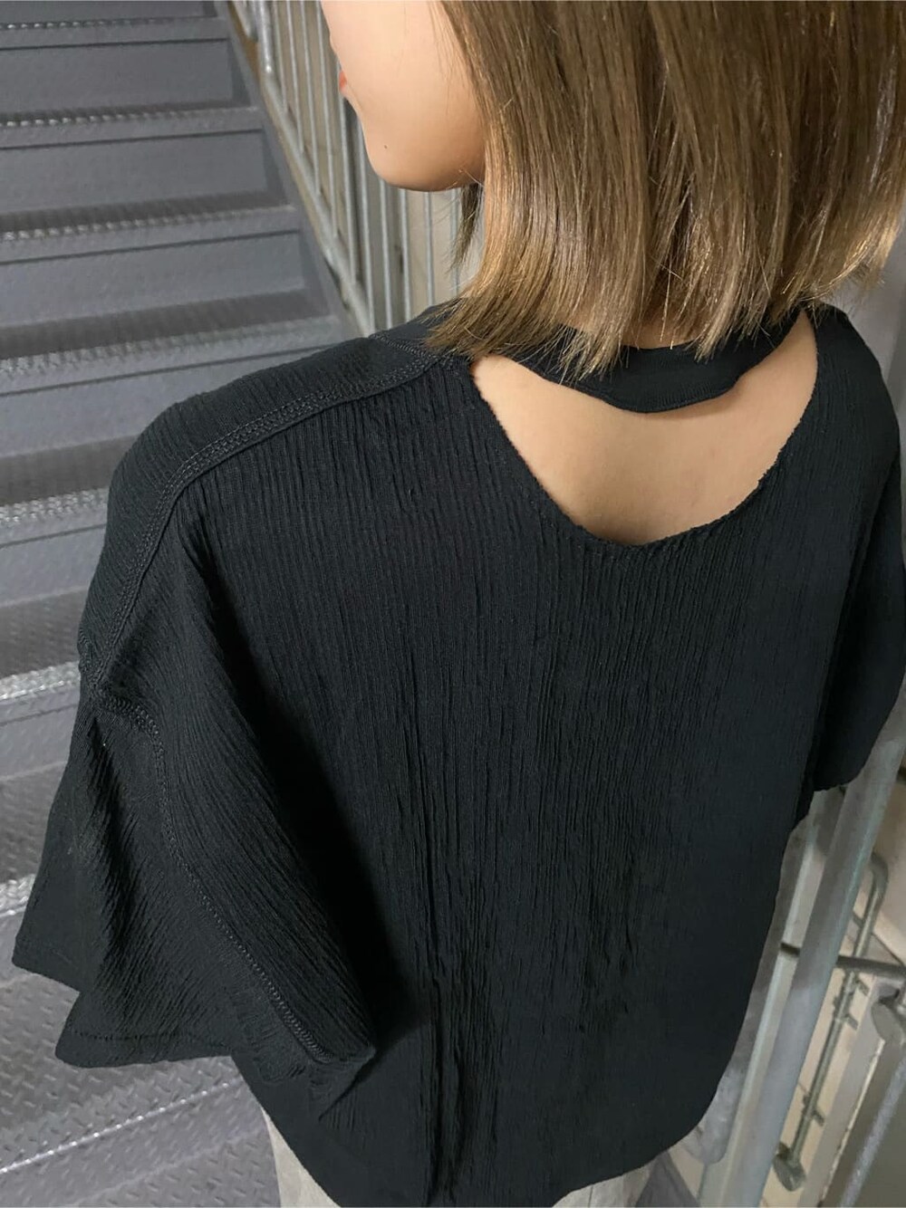 グレー系のスカート、ブラック系のサンダル、ブラック系のTシャツ/カットソーを着用したレディースの夏コーディネートの4枚目の写真