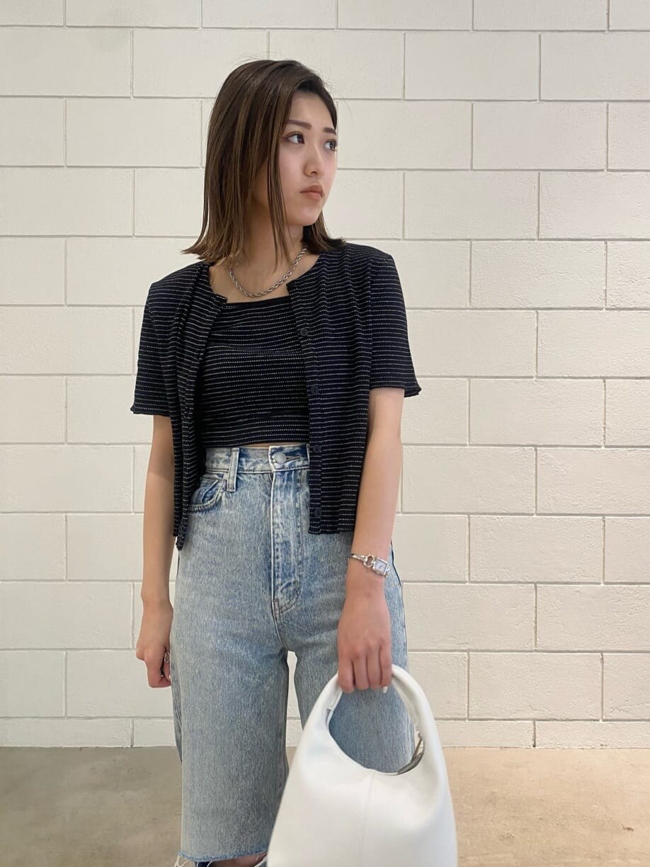 ブラック系のサンダル、ホワイト系のハンドバッグ、ブルー系のデニムパンツを着用したレディースの夏コーディネートの6枚目の写真