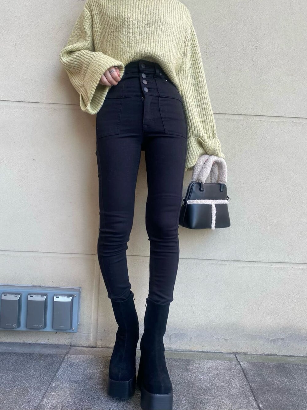 ブラック系のブーツ、ブラック系のハンドバッグ、イエロー系のニット/セーターを着用したレディースの秋コーディネートの5枚目の写真