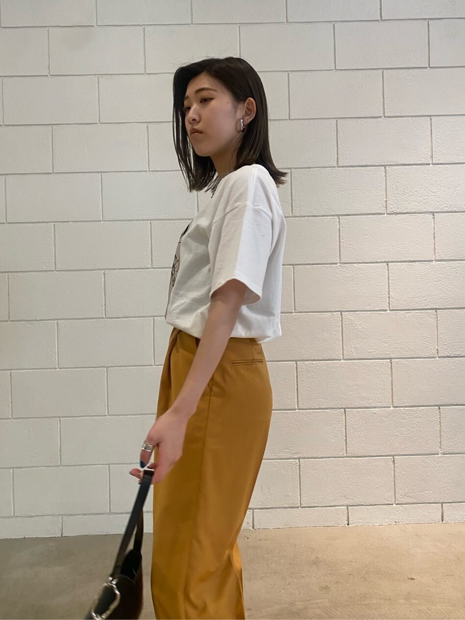 オレンジ系のその他パンツ、ブラック系のハンドバッグ、ホワイト系のTシャツ/カットソーを着用したレディースの春コーディネートの6枚目の写真