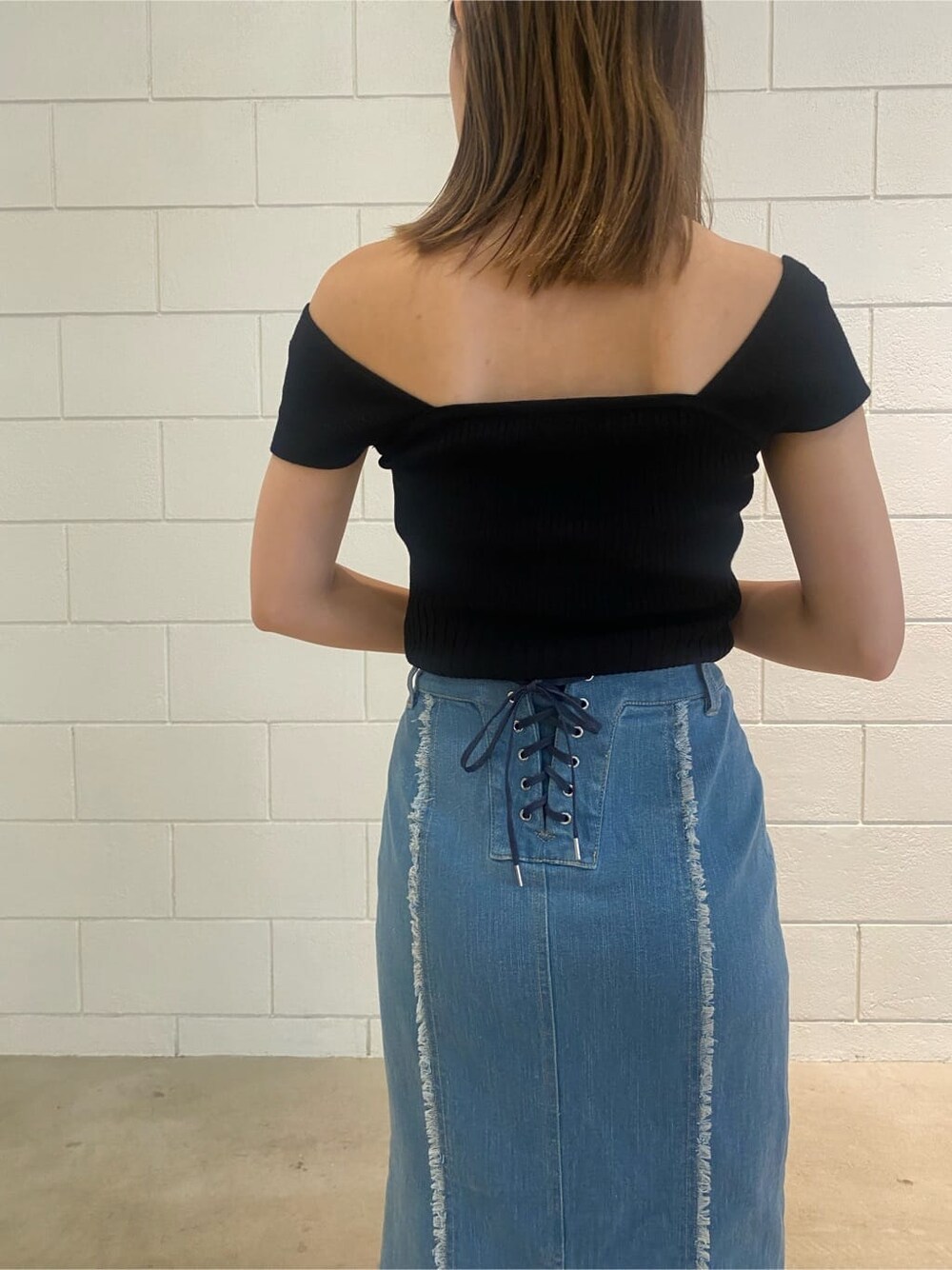 ブラウン系のハンドバッグ、ブルー系のスカート、ブラック系のタンクトップを着用したレディースの夏コーディネートの6枚目の写真