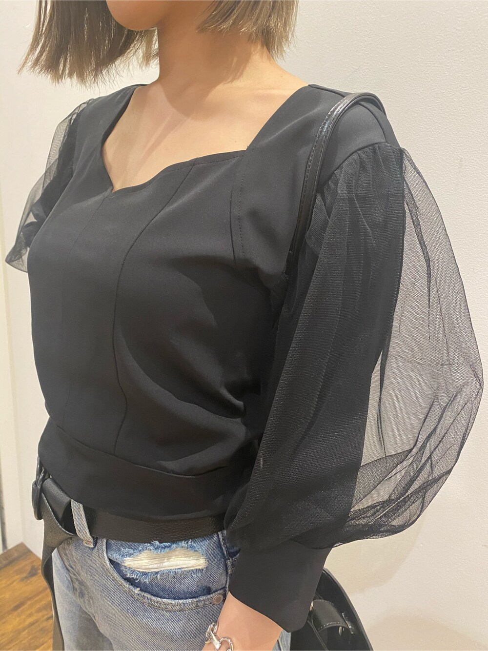 ブラック系のショルダーバッグ、ブルー系のデニムパンツ、ブラック系のシャツ/ブラウスを着用したレディースの春コーディネートの3枚目の写真