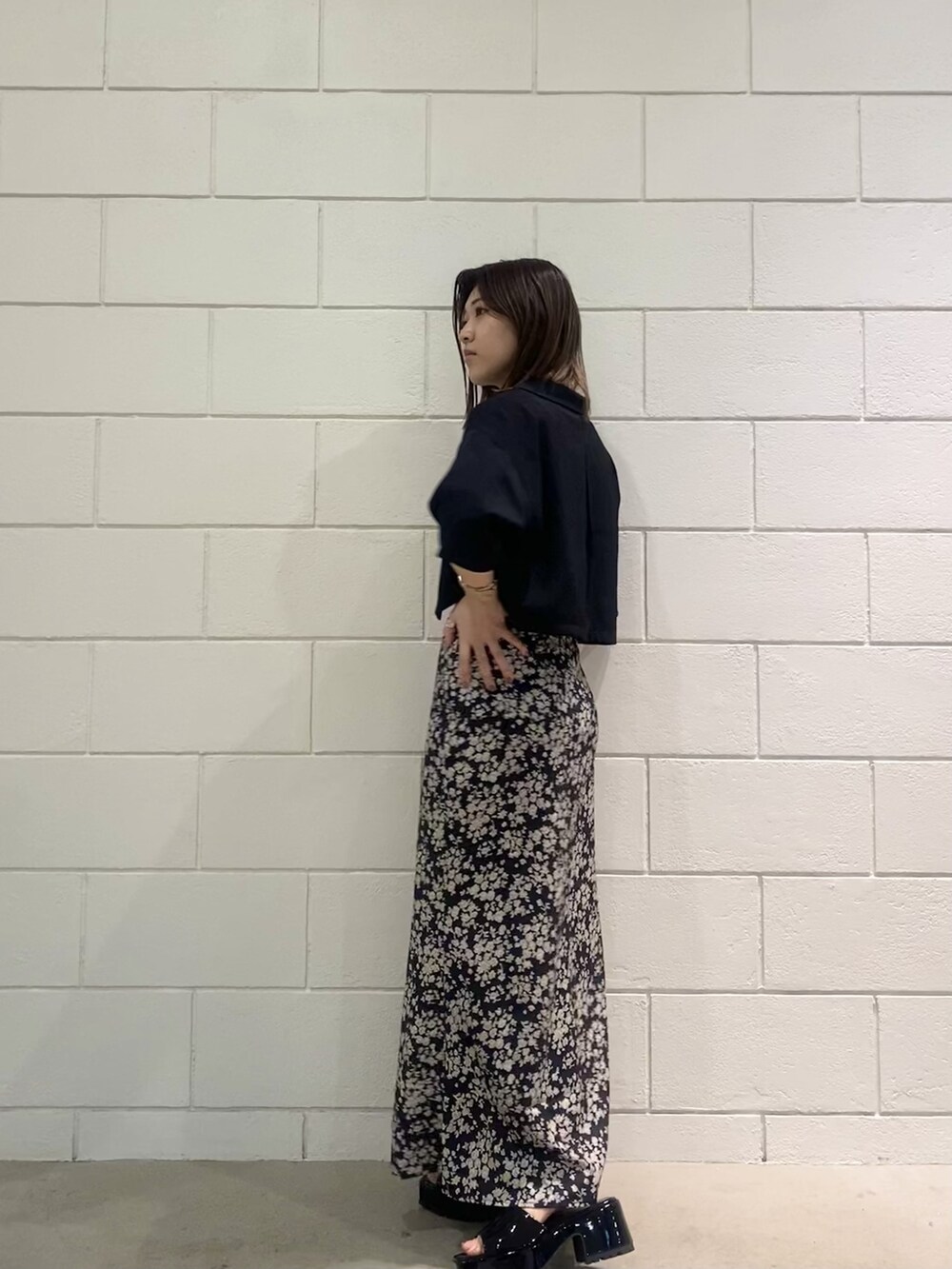 ブラック系のサンダル、ブラック系のシャツ/ブラウス、ホワイト系のTシャツ/カットソーを着用したレディースの春コーディネートの2枚目の写真